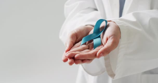 青い卵巣癌のリボンを持っている白人医師の中央部のビデオ コピースペースと 医療サービス 医療と健康意識の概念 — ストック動画