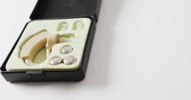 İşitme cihazının ve bataryaların beyaz arka planda fotokopi alanındaki videosu. Tıp, duyular, işitme, sağlık, sağırlık ve sağlık farkındalığı kavramı.