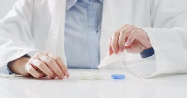 Beyaz bir doktorun lens kutusuna lens koyarken çekilmiş bir video. Tıp, duyu, görüş, sağlık ve sağlık farkındalığı kavramı.