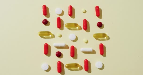 Vídeo Una Variedad Píldoras Cápsulas Dispuestas Sobre Fondo Amarillo Con — Vídeos de Stock