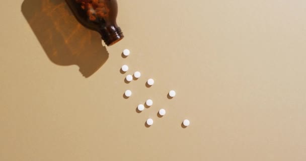 Video Brown Bottle Spilling White Pills Brown Background Copy Space — Stock Video