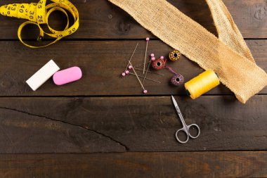 Ahşap arka planda fotokopi alanı olan dikiş ekipmanı bileşimi. Ulusal zanaat ayı, dikiş, zanaat ve dikiş konsepti.