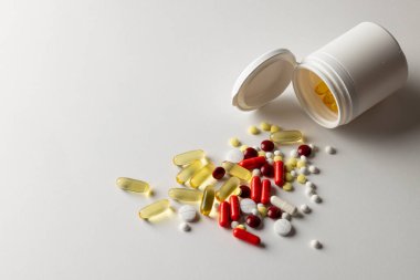 İlaç kutusunun kompozisyonu beyaz arka planda farklı ilaç ve kapsülleri fotokopi alanlarıyla dolduruyor. Tıp, sağlık hizmetleri, sağlık hizmetleri ve sağlık farkındalığı kavramı.