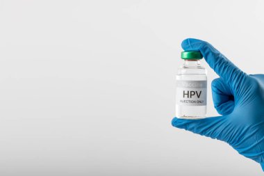 Eldivenli eldiven, beyaz arka planda fotokopi aletiyle HPV aşı şişesini tutuyor. Tıp, sağlık hizmetleri, sağlık hizmetleri ve sağlık farkındalığı kavramı.