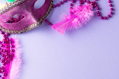 Mavi arka planda pembe Mardi Gras boncukları ve karnaval maskesi kompozisyonu. Parti, kutlama ve karnaval konsepti.