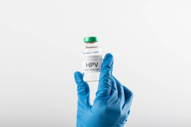 Doktorun eldivenli eli, beyaz arka planda fotokopi alanı olan HPV aşı tüpünü tutuyor. Tıp, sağlık hizmetleri, sağlık hizmetleri ve sağlık farkındalığı kavramı.