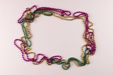 Beyaz arka planda renkli Mardi Gras boncuklarının kompozisyonu, kopyalama alanı ile. Parti, kutlama ve karnaval konsepti.