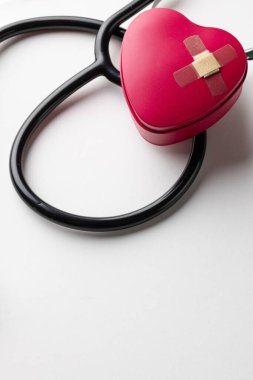 Stetoskop ve kalbin kompozisyonu. Beyaz arka plana yapıştırılmış alçı ve fotokopi alanı. Sağlık hizmetleri, sağlık hizmetleri ve sağlık farkındalığı kavramı.