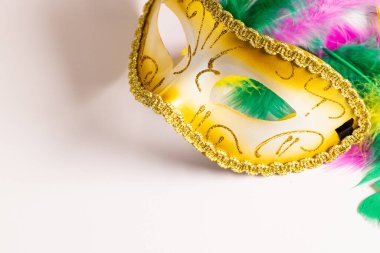Renkli Mardi Gras karnaval maskesi. Beyaz arka planda tüyleri ve kopyalama alanı var. Parti, kutlama ve karnaval konsepti.