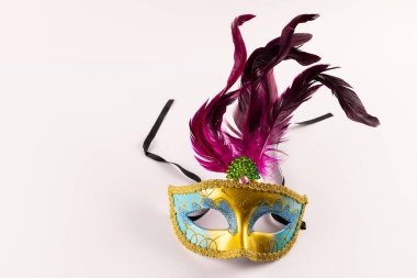 Renkli Mardi Gras karnaval maskesi. Beyaz arka planda tüyleri ve kopyalama alanı var. Parti, kutlama ve karnaval konsepti.