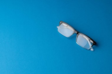 Mavi arkaplanda fotokopi alanı olan gözlük bileşimi. Sağlık hizmetleri, sağlık hizmetleri ve sağlık farkındalığı kavramı.