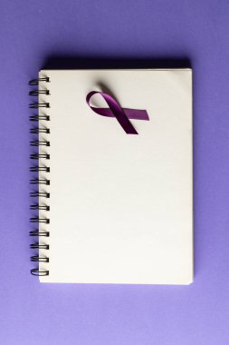 Mor eklentinin dikey hali veya not defterinde mor arkaplanda kopyalama alanı olan bir farkındalık kurdelesi. Sağlık hizmetleri, sağlık hizmetleri ve zihinsel sağlık farkındalığı kavramı.