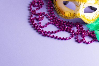Mavi arka planda renkli Mardi Gras boncukları ve karnaval maskesi kompozisyonu. Parti, kutlama ve karnaval konsepti.