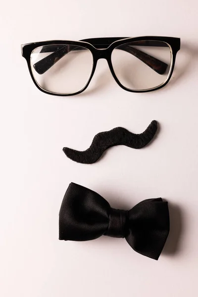 コピースペースと白い背景に眼鏡と蝶ネクタイで偽の口ひげの構成 偽の口ひげの日 パーティー お祝いや衣装の概念 — ストック写真