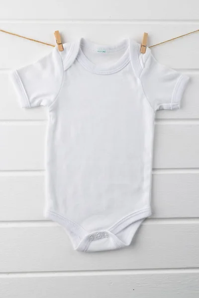白い背景にコピースペースのあるベビーホワイトのTシャツを閉じます 衣類やアクセサリー 新生児や幼児の育児の概念 — ストック写真