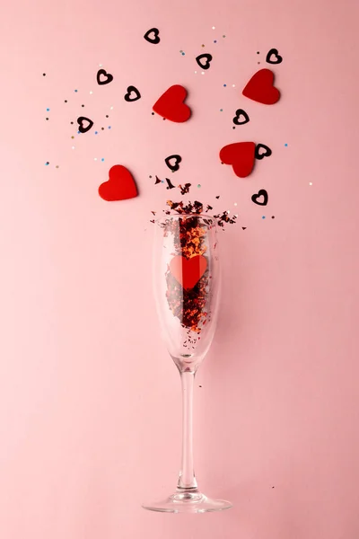 Vertical Champagne Glass Spilling Red Heart Shapes Pale Pink Background — Stock Photo, Image