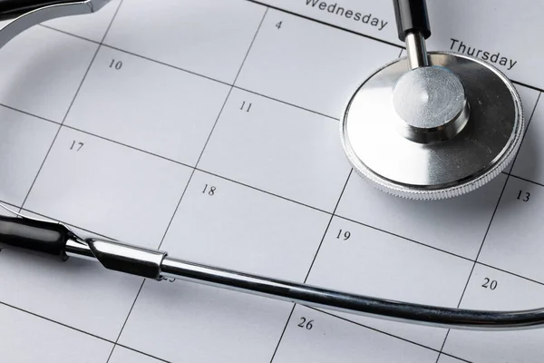 Close up, full frame composition of stethoscope on calendar. Medical services, healthcare and health awareness concept.