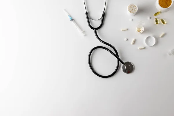 Zusammensetzung Des Stethoskops Mit Spritze Und Pillen Auf Weißem Hintergrund — Stockfoto