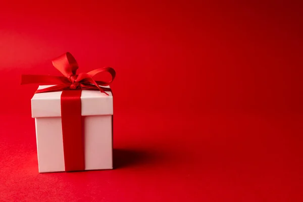 Weiße Geschenkschachtel Mit Roter Schleife Gebunden Auf Rotem Hintergrund Mit — Stockfoto