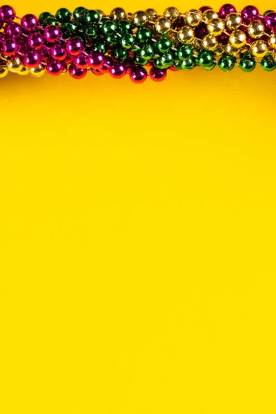 Состав Разноцветных Бусин Марди Гра Желтом Фоне Копировальным Пространством Концепция — стоковое фото