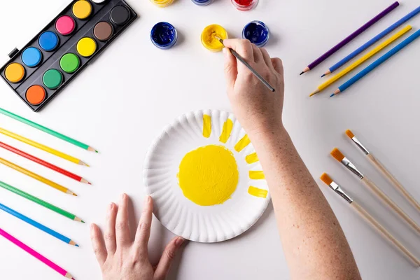 Overhead Hands Painting Yellow Paint Paper Plate Art Materials Table — Stock Photo, Image
