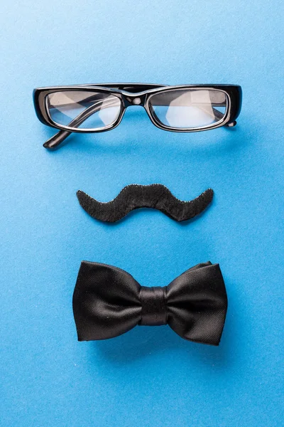 コピースペースと青の背景に眼鏡と蝶ネクタイで偽の口ひげの構成 偽の口ひげの日 パーティー お祝いや衣装の概念 — ストック写真