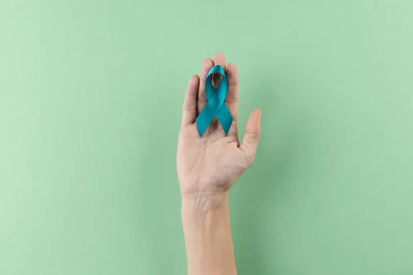 Zusammensetzung Der Hand Mit Blauem Eierstockkrebs Bewusstseinsband Auf Grünem Hintergrund — Stockfoto