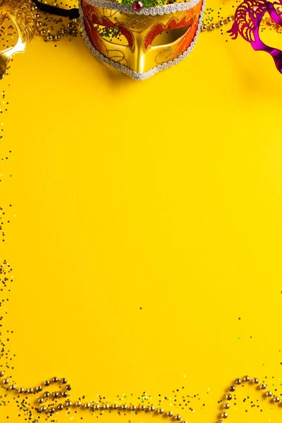 色彩斑斓的杏仁珠和狂欢节的面具在黄色背景与复制空间的组合 庆祝和狂欢节的概念 — 图库照片