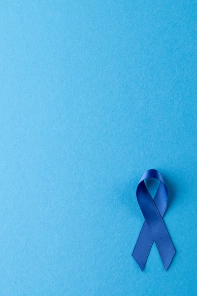 Vertical of blue ribbon for prostate cancer awareness, on blue background with copy space. Medicine, healthcare and health awareness concept.