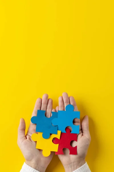 Vertical Composition Hands Holding Jigsaw Puzzle Pieces Yellow Background Copy — Stock Photo, Image