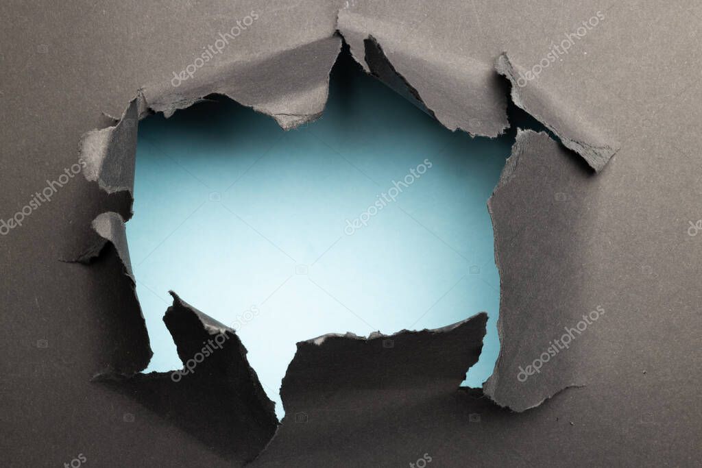 Ripped up piece of black paper with copy space on white background. Abstract paper texture background and communication concept.
