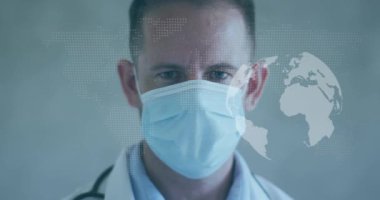 Yüz maskeli beyaz erkek doktor üzerinde dünya haritası ve yerkürenin animasyonu. Küresel tıp ve dijital arayüz kavramı dijital olarak oluşturulmuş video.
