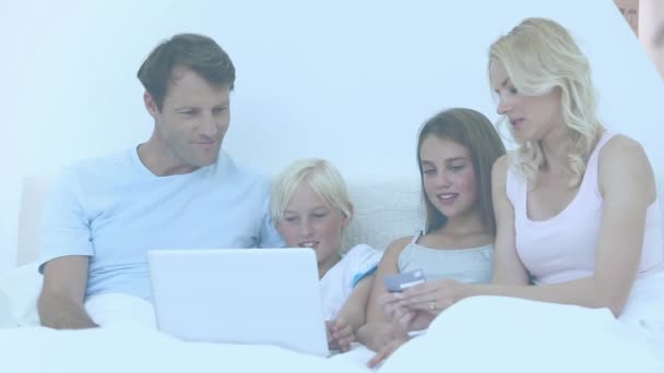 一对夫妇带着儿子和女儿使用笔记本电脑用信用卡在线支付的视频 全球网上购物 数字接口和数据处理概念 — 图库视频影像