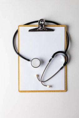 Beyaz arkaplanlı ve fotokopi alanı olan steteskopun dikey bileşimi. Sağlık hizmetleri, sağlık hizmetleri ve sağlık farkındalığı kavramı.