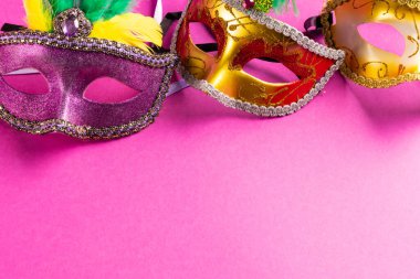 Renkli Mardi Gras karnaval maskelerinin kompozisyonu pembe arka planda fotokopi alanı ile. Parti, kutlama ve karnaval konsepti.
