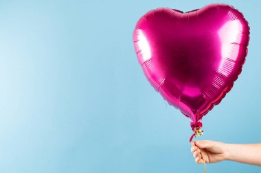 Mavi arka planda yüzen parlak pembe kalp şeklinde balon, fotokopi alanı ile. Aşk, romantizm, sevgililer günü ve kutlama konsepti.