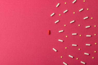 Kırmızı arkaplanda fotokopi alanı ile düzenlenmiş çeşitli hapların bileşimi. Tıp, sağlık hizmetleri, sağlık hizmetleri ve sağlık farkındalığı kavramı.