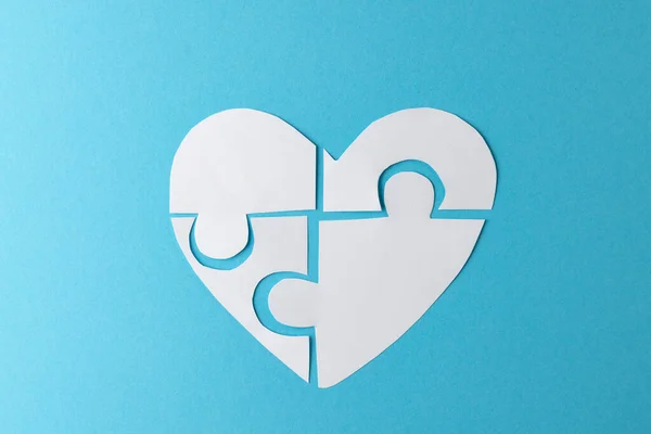 stock image Composition of white heart made of jigsaw puzzle pieces on blue background, with copy space. Medicine, healthcare and health awareness concept.