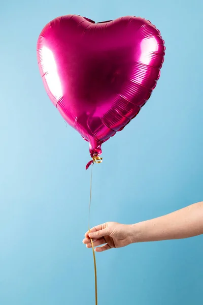 Verticale Afbeelding Van Hand Houden Glanzend Roze Hart Ballon Zwevend — Stockfoto