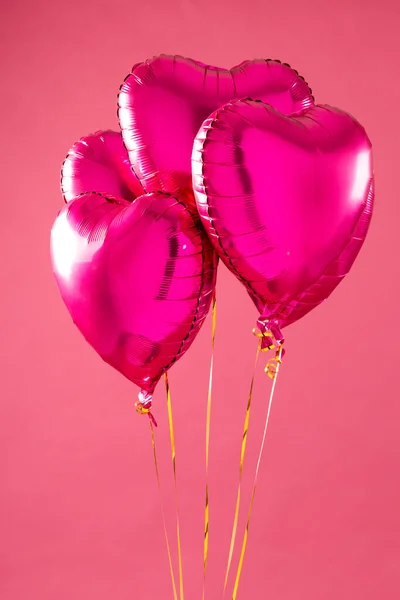Verticaal Van Vier Glanzende Roze Hartvormige Ballonnen Zwevend Witte Achtergrond — Stockfoto