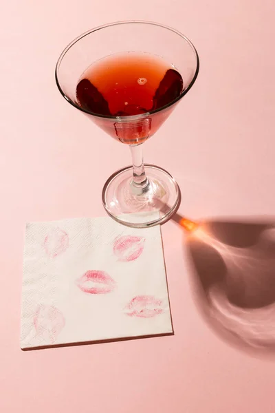 红色鸡尾酒的垂直 餐巾纸上有口红的痕迹 粉红的背景上有复制空间 情人节 浪漫和庆祝的理念 — 图库照片