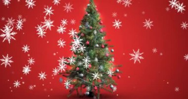 Kırmızı arka planda süslenmiş Noel ağacının üzerine düşen kar taneleri ikonlarının canlandırılması. Noel şenliği ve kutlama konsepti