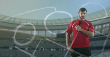 Profesyonel rugby oyuncusu bir spor stadyumunun önünde duruyor.