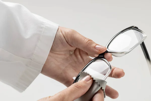Środkowa Część Kaukaskiego Lekarza Trzymającego Czyszczącego Okulary Szarym Tle Koncepcja — Zdjęcie stockowe