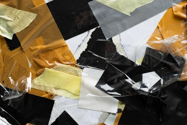 stock image Collage of overlapping pieces of black, white, brow and grey masking tape on torn paper. Abstract paper texture, repair and distressed background concept.