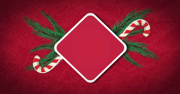 Kırmızı arkaplanda kopya alanı olan şeker kamışı ve köknar ağacı resmi. Noel, gelenek ve kutlama konsepti dijital olarak oluşturulmuş imaj.