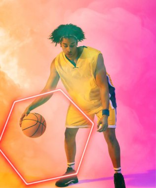 Duman gibi arka planda parlayan altıgenle basketbol oynayan çift ırklı erkek oyuncunun birleşimi. Boşluğu kopyala, pembe, spor, rekabet, illüstrasyon, aydınlatma, şekil ve soyut kavram.