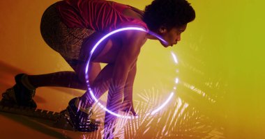 Çift ırklı bayan sporcunun aydınlanmış bitkiler ve çemberle başlangıç pozisyonunda bükülmesinin yan görüntüsü. Boşluğu kopyala, kompozit, koşu, spor, rekabet, yarış, şekil, doğa ve soyut kavram.