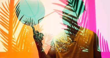 Aydınlatılmış renkli bitkiler ve altıgen parmak üzerinde basketbol oynayan çift ırklı erkek oyuncu üzerinde. Bileşik, spor, rekabet, illüstrasyon, parlama, doğa, şekil ve soyut kavram.