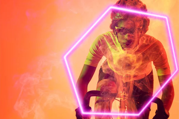 stock image Hexagon neon over determined african american cyclist riding bicycle against orange background. Digital composite, sport, cycling, athlete, copy space, competition.